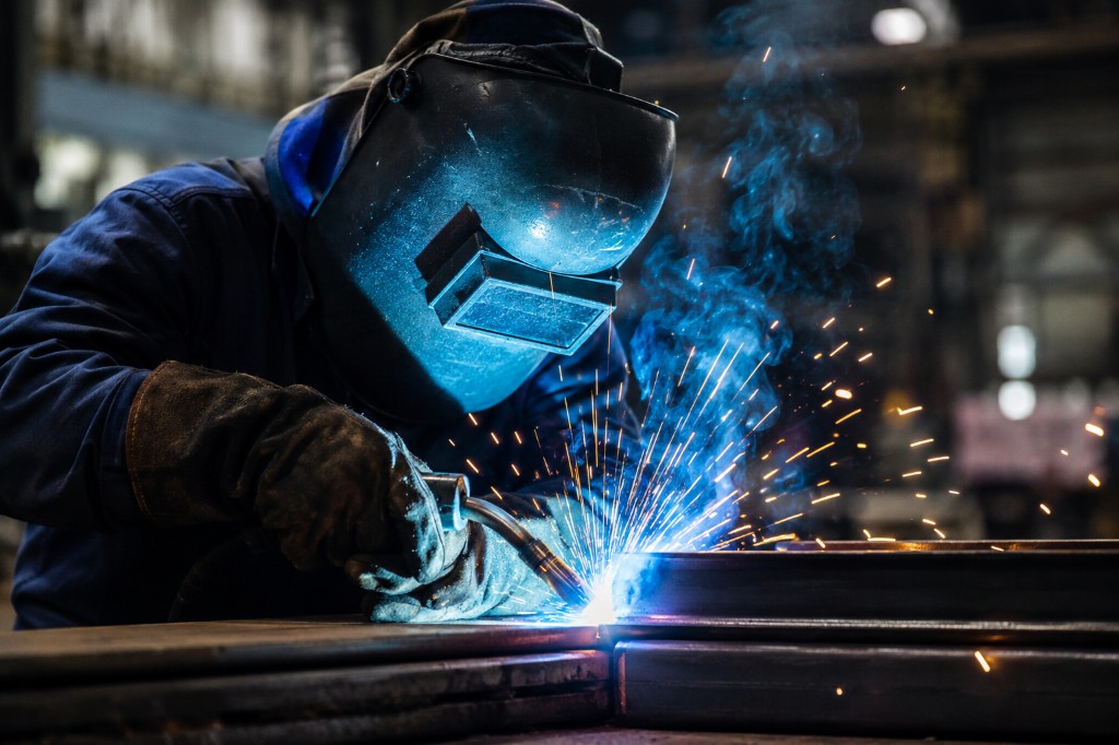 Welder making sparks while welding steel on-site